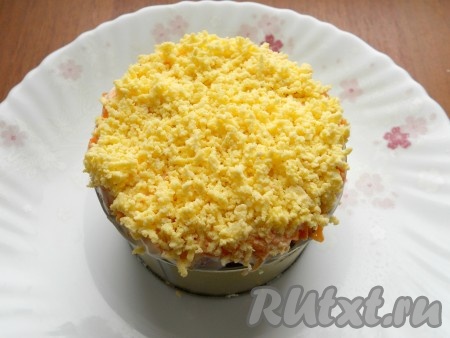 Смазать рыбу майонезом, на нее - слой оставшейся натертой моркови. Также смазать немного майонезом. И сверху посыпать натертым на мелкой терке вареным желтком.
