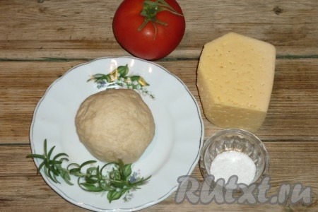 Для приготовления теста для пиццы смешать муку с дрожжами, сахаром и солью, влить тёплую воду, растительное масло, замесить эластичное тесто, сформировать из него шар, накрыть полотенцем и оставить на 1 час в тёплом месте. Тесто поднимается не очень сильно. Оно становится более мягким и немного увеличивается в объеме. 