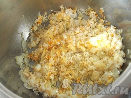 Хорошо промыть чечевицу, выложить её в кастрюлю, залить 0,5 литрами чистой холодной воды, поставить на огонь, а после закипания варить на небольшом огне минут 25-30 (до мягкости чечевицы). За 5 минут до окончания варки посолить чечевицу. В другой кастрюле разогреть немного растительного масла, затем выложить очищенный и мелко нарезанный лук. Обжарить лук на среднем огне, иногда помешивая, до мягкости (ориентировочно в течение 3-4 минут). К обжаренному луку добавить промытый рис, перемешать.