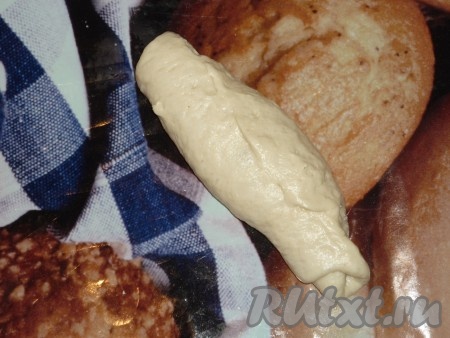 Затем свернуть тесто в рулет, начиная с широкой стороны овала.