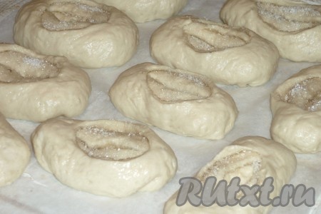 Аналогично сформировать и выложить гладкой сторон вверх все заготовки булочек на расстоянии друг от друга. Ножом на каждой булочке сделать глубокий надрез. Главное не прорезать полностью, чтобы сахар не высыпался. Немного вывернуть серединку. Оставить булочки на расстойке минут на 25-30. Затем в небольшой пиале яйцо взбить вилкой до однородности. Сахарные булочки смазать яйцом и отправить в разогретую до 180 градусов духовку на 30-35 минут.&nbsp;