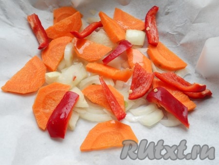 Если готовить с овощами, их очистить и крупно нарезать. Поместить овощи на пергамент, которым застелить форму для запекания, влить растительное масло.
