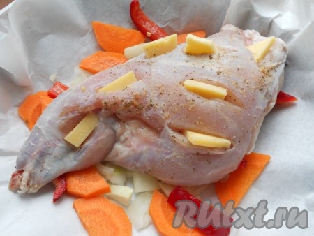 Ножку кролика обсушить бумажным полотенцем, посолить, посыпать специями со всех сторон. В надрезы вложить кусочки твердого сыра (как на фото) и поместить кролика на овощи.
