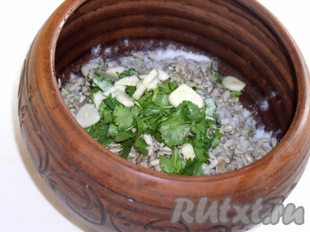 Переложить чеснок и кинзу к семечкам и добавить соль.