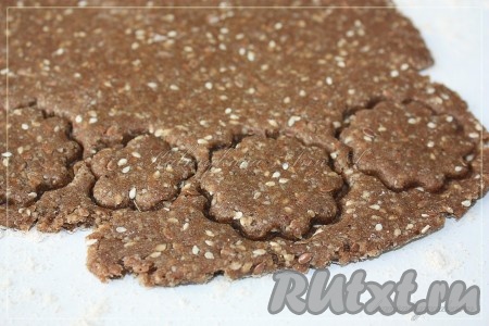 Раскатать тесто толщиной 3-5 мм и вырезать формочкой крекеры или просто нарезать квадратами.
