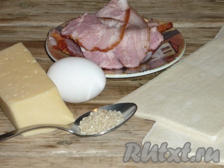 Подготовить продукты для приготовления слоек с ветчиной и сыром. Слоёное бездрожжевое тесто разморозить при комнатной температуре (тесто должно стать мягким). Ветчину нарезать на кусочки.