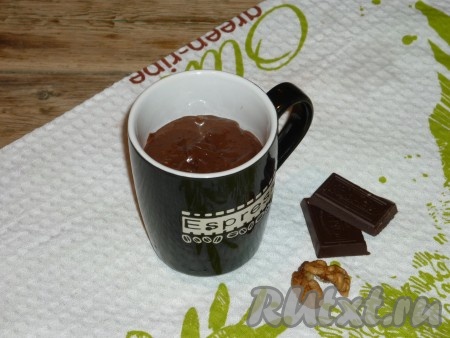 Кружку, которая подходит для выпечки в микроволновой печи, слегка смазать растительным маслом. Тесто выложить в кружку, заполняя её на 1/2 объёма, так как при выпекании шоколадный кекс очень хорошо поднимается.