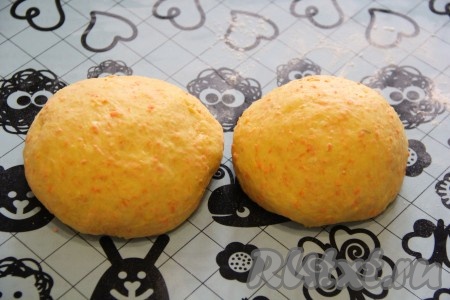 Готовое тесто хорошо обмять. Сформировать дрожжевой пирог с морковью или булочки из этого теста можно по-разному. Я решила сделать красивый каравай. Тесто разделить на 2 части: одна часть должна быть чуть больше другой.
