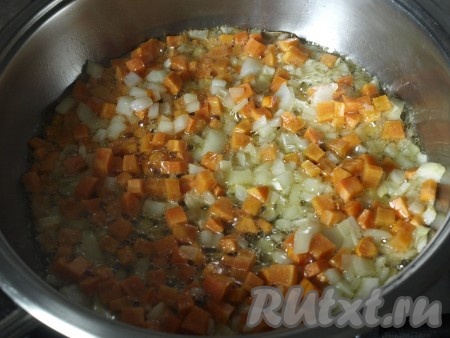 Разогреть в сковороде растительное масло, выложить лук с морковью и обжарить овощи, не забывая иногда перемешивать, на среднем огне в течение 5 минут.