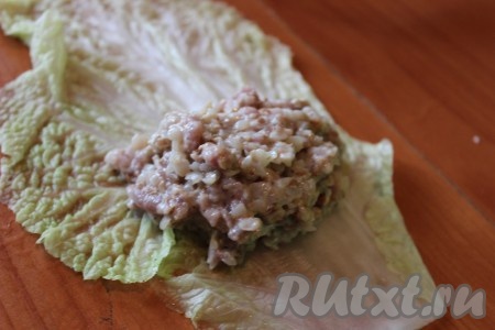 На каждый подготовленный капустный лист выложить по 1-1,5 столовых ложки фарша и аккуратно завернуть.
