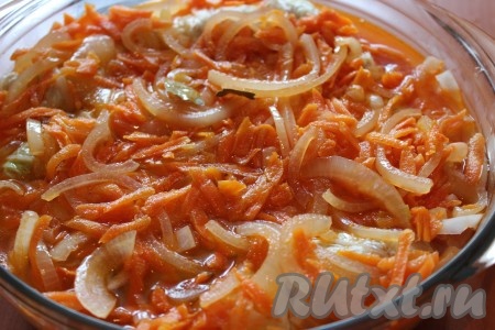 Далее в жаропрочную форму с голубцами влить теплую воду или овощной бульон, покрывая голубцы полностью (мне понадобилось 300 мл воды). Аккуратно выложить на голубцы подготовленную заправку из моркови с луком. Накрыть крышкой или фольгой. Если используете фольгу, тогда проколите ее в нескольких местах. Поставить форму в разогретую до 180 градусов духовку и запекать 30-35 минут.
