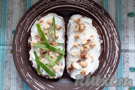 Добавьте на бутерброд дробленый фундук и тонко нарезанную зелень.