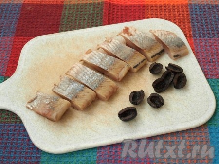 Разобрать селёдку на филе, удалив косточки, нарезать на порционные кусочки. Каждую маслину разрезать пополам.