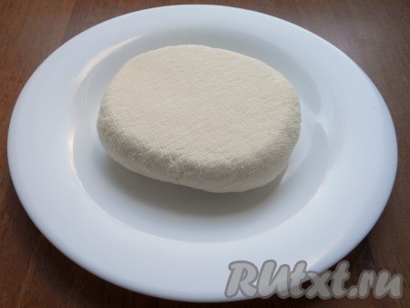 Далее марлю с творогом завязать и подвесить, чтобы вся сыворотка стекла. Затем на творог в марле поместить тяжелый гнёт (я ставлю сверху разделочную доску, на неё ставлю банку с водой) и оставить в таком положении на 1 час. Через час убрать гнёт и марлю, у вас должен получиться ещё чуть тёплый, плотный сыр.