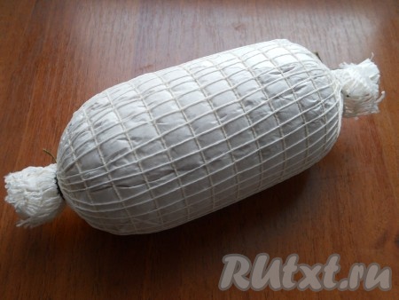 Плотно свернуть пергамент, края скрутить и завязать (завязывать нужно тщательно). Фарш должен быть смотан как можно плотнее. Сверху надеть специальную сетку, также зафиксировать концы. Если такой сетки нет, просто плотно перевяжите ветчину бичевкой.