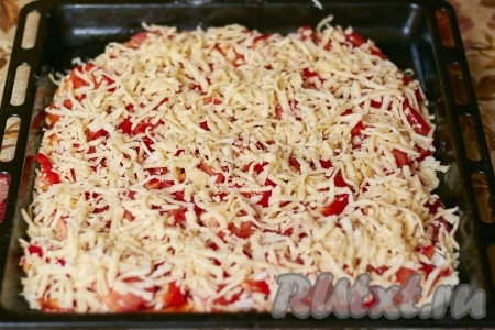 Сыром, натёртым на крупной тёрке, посыпать курино-овощную начинку пиццы.