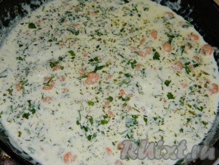К обжаренным креветкам добавить нарезанную зелень, влить сливки, посолить и поперчить по вкусу. Довести до кипения, уменьшить огонь до минимума, протушить креветки в сливочном соусе с чесноком 1-2 минуты.