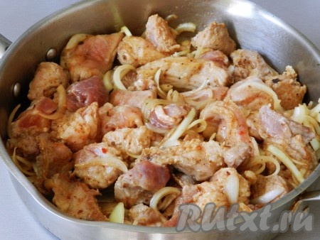 В сковороде разогреть растительное масло и выложить в неё свинину с луком вместе с соусом. Перемешать и жарить на достаточно большом огне, периодически переворачивая кусочки.