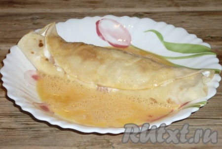 Яйцо взболтать вилкой с щепоткой соли. Твёрдый сыр натереть на терке. Подготовленный блинчик с начинкой мокнуть сначала в яйцо,