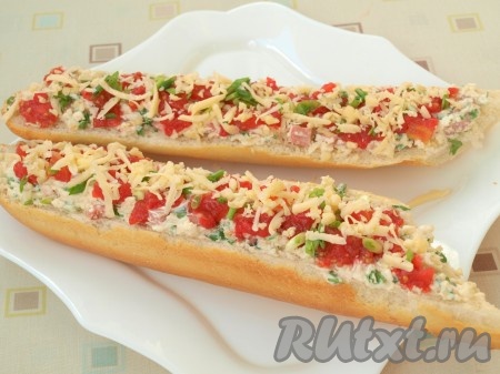 Поверх начинки выложить нарезанный кубиками помидор, измельченный зелёный лук и оставшийся натёртый твёрдый сыр.
