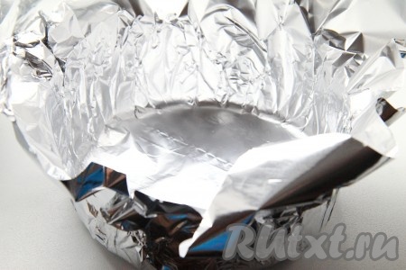 Так как филе тилапии будет запекаться, то подойдет любая подходящая форма или противень. Я же предпочитаю подавать это блюдо порционно. Это не только удобно, ведь не нужно лишний раз мыть посуду, но и более эстетично, особенно если приходится готовить на праздники. Для этого я делаю из фольги одноразовые формочки на каждого члена семьи. Делаются они очень просто и быстро на самом деле. Отрезаем небольшой кусок фольги и находим подходящую по размеру емкость. У меня это небольшая кастрюлька. Переворачиваем ее вверх дном и оборачиваем дно фольгой, затем прижимаем ее по кругу и аккуратно снимаем.
