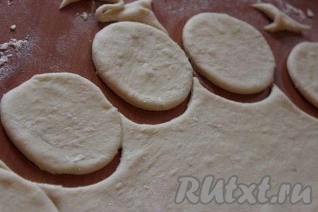 Рабочую поверхность припылить мукой, тонко раскатать тесто. Вырезать стаканом круги диаметром, примерно, 10 сантиметров.
