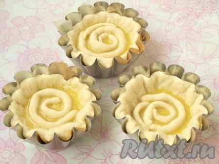 Из теста, которое мы отложили, скатать жгутики и выложить их прямо на начинку по спирали. Дать булочкам подняться в течение 20 минут, прикрыв их полотенцем.
