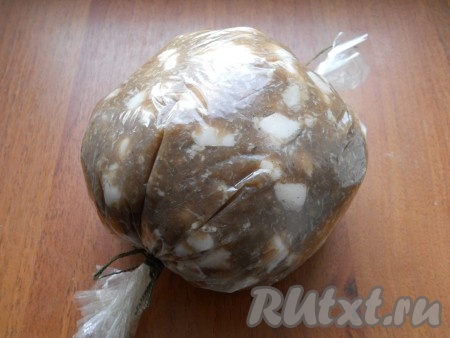 Далее следует очень плотно набить колбасные оболочки диаметром 120 мм, у меня не оказалось оболочки нужного диаметра, поэтому я поместила фарш в рукав для запекания, сформировала шар и зафиксировала тщательно концы. Подвесить колбасу на 2-3 часа при температуре от 0 до +4 градусов, лучше в холодильнике.
