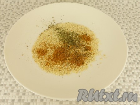 В небольшую ёмкость всыпать специи (я добавила 0,5 чайной ложки специй для мяса, 0,5 чайной ложки хмели-сунели, красный молотый перец), по желанию, добавить кунжут, перемешать.