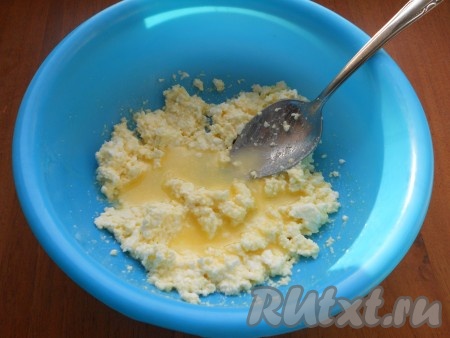 Тщательно растереть творог с желтком и сахаром столовой ложкой (или вилкой), влить растопленное тёплое сливочное масло и перемешать.