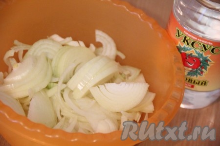 Выложить лук в глубокую миску, добавить уксус.