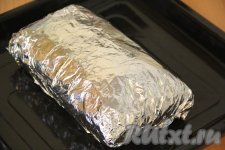 Плотно завернуть свинину с луком в фольгу. Выложить мясо на противень и в таком виде оставить промариноваться на 2 часа при комнатной температуре. Лук отлично размягчает мясо, после такого маринования мясо становится более мягким, а значит в готовом виде свиной карбонад будет очень нежным.