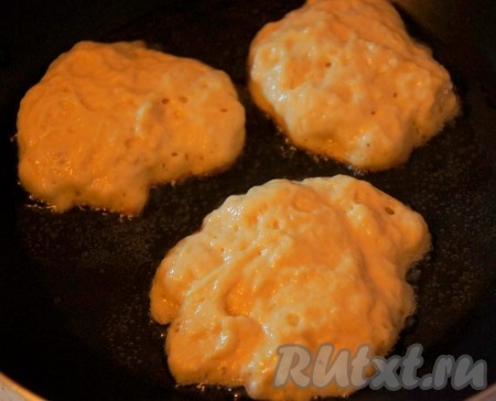 Сковороду нагреть с добавлением растительного масла. Столовую ложку смочить водой (я слегка смачиваю ложку водой каждый раз перед набором очередной порции теста). Выкладывать на сковороду по 1 столовой ложке дрожжевого теста в виде оладий.&nbsp; Жарить оладьи на среднем огне с двух сторон до образования румяной корочки (примерно по 2-3 минуты с каждой стороны). Оладьи в процессе жарки должны ещё подняться. Готовые оладьи переложить со сковороды на тарелку. Постепенно пожарить все дрожжевые оладушки, выкладывая тесто на сковороду столовой ложкой, смоченной в воде. Перемешивать тесто в процессе жарки не нужно.