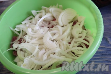 Свинину выложить в глубокую миску, добавить нарезанный лук. 