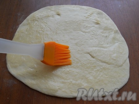 Далее каждую часть нужно тонко раскатать в лепешку. Две лепешки смазать растопленным сливочным маслом.