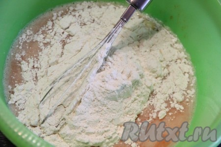 Далее частями всыпать муку, перемешивая тесто венчиком. Мука у всех разная, поэтому очень важно, всыпая муку, ориентироваться на консистенцию замешиваемого теста.