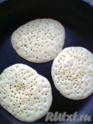 Сразу приступаем к жарке оладий. Разогреваем сковороду (я перед жаркой оладий сковородку маслом не смазывала, если не уверены в качестве покрытия сковороды, тогда слегка смажьте её маслом). Выкладываем на сковороду по 1,5-2 столовых ложки теста, слегка размазываем, формируя оладьи. Жарим на среднем огне до появления пузырьков по всей поверхности оладушка (это произойдет через 2-3 минуты с начала жарки).