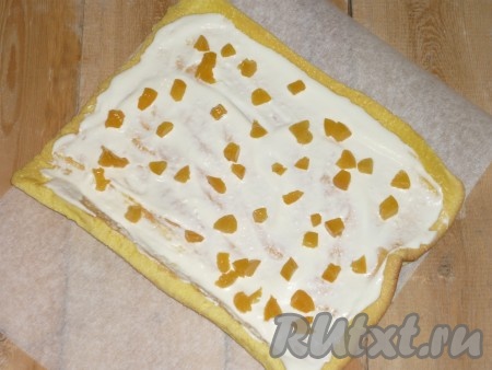 Остывший рулет развернуть и смазать творожным кремом. Сверху равномерно выложить абрикосы, нарезанные кусочками.&nbsp;
