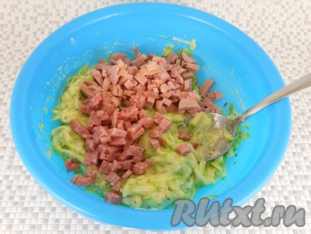 Снова все тщательно перемешать и добавить нарезанную мелкими кубиками колбасу двух видов (можете использовать любую колбасу).
