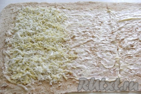 Натереть на крупной тёрке яйца и выложить на лаваш в виде полоски.

