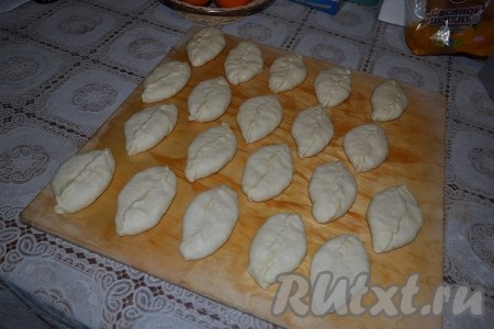 Каждый шарик руками разминаем в лепёшку, в середину кладём желаемое количество начинки (например, тушёную капусту или грибы, жареные с луком), защипываем края лепёшки, формируя пирожок с начинкой. Сформированный пирожок немного приминаем ладонью.