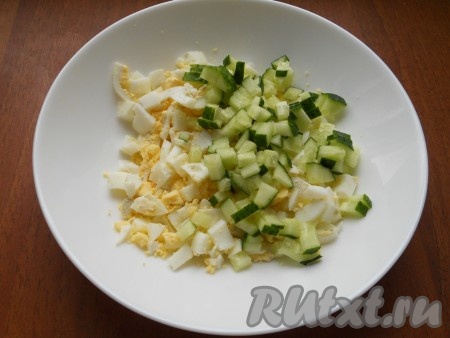 Яйца, сваренные вкрутую, остудить, очистить и нарезать небольшими кусочками. Добавить к вареным яйцам нарезанный небольшими кубиками огурчик. 