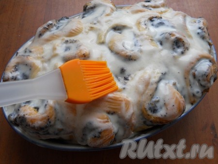 Готовые горячие булочки полить или смазать кисточкой (обильно) сметанной заливкой. Накрыть форму с булочками фольгой и оставить до почти полного остывания.
