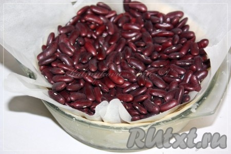 По истечении времени достать тесто из морозилки, накрыть его пергаментом, сверху положить любой утяжелитель (у меня фасоль, в качестве утяжелителя) и отправить в духовку, разогретую до 170 градусов, минут на 15-20.
