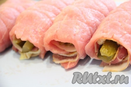 Для того чтобы наши мясные рулеты с начинкой не распались во время приготовления, лучше перевязать каждый рулетик плотной ниткой. Вот такие рулетики из свинины с беконом получились у меня.