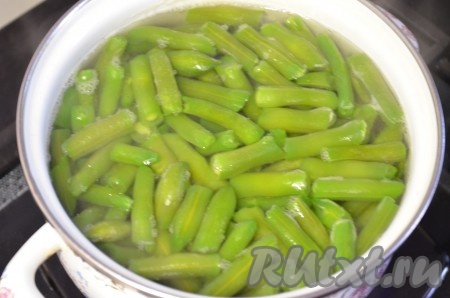 Стручковую фасоль (свежую или замороженную) поместить в кипящую воду и варить на небольшом огне до готовности, примерно 5-8 минут с момента закипания, затем воду слить.
