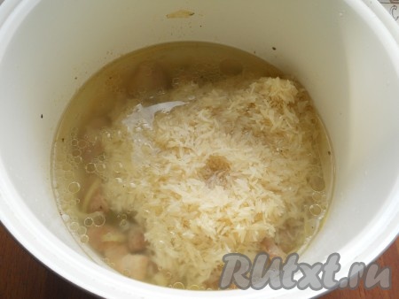 Свинину немного посыпать специями для мяса. Далее готовить еще 15 минут с открытой крышкой, периодически мясо перемешивая, добавить репчатый лук, перемешать и готовить оставшееся время. После этого всыпать к мясу в чашу мультиварки рис, влить горячую воду, добавить соль по вкусу.
