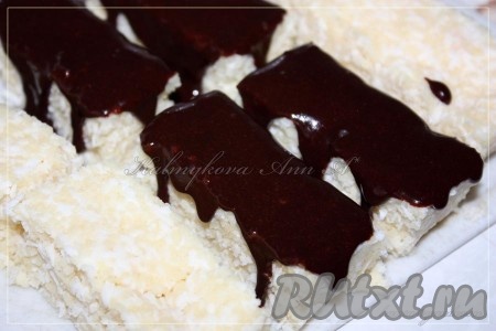 Достать из холодильника заготовку, разрезать порционно и полить шоколадной глазурью, оставить застывать. Хранить кокосовый десерт в холодильнике.

