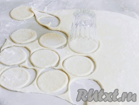 Затем разделить тесто на 4 части. Часть теста раскатать в пласт толщиной в 2-3 мм и вырезать кружки для будущих пельменей. Остальное тесто держать под полотенцем. 