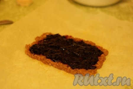 Выложить тесто на бумагу для выпечки, формируя тонкий прямоугольник. Сверху нанести слой варенья, как на фото.
